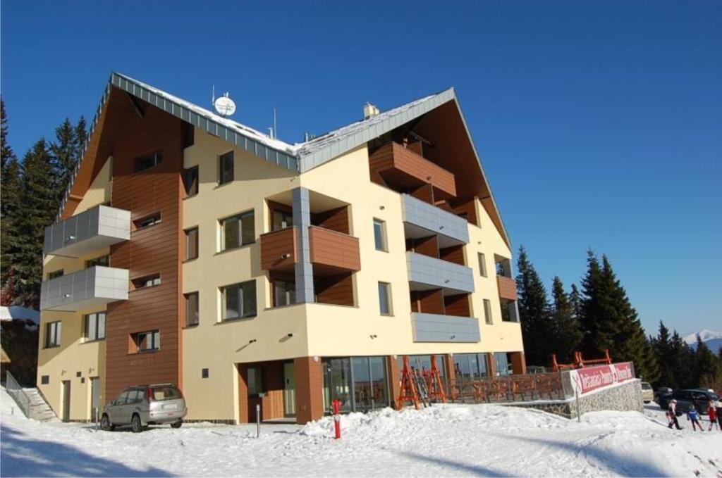 马汀Martinske Hole, Apartman, Nova Ponorka的雪中一座大建筑,前面有滑雪板