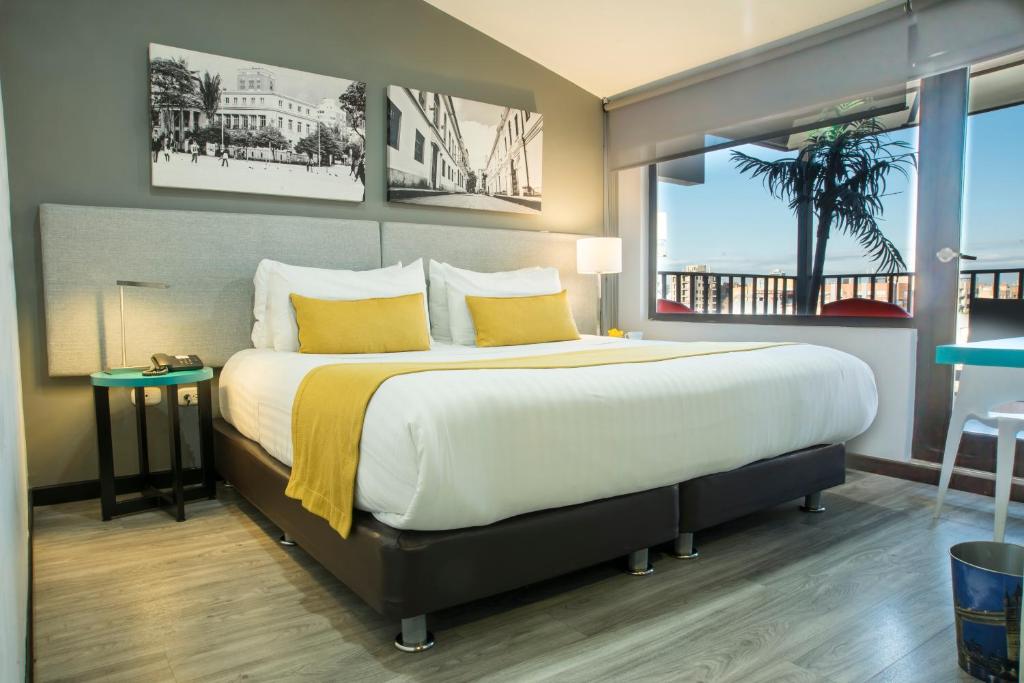 波哥大Hotel City Bog 106的一间卧室配有一张带黄色枕头的大床