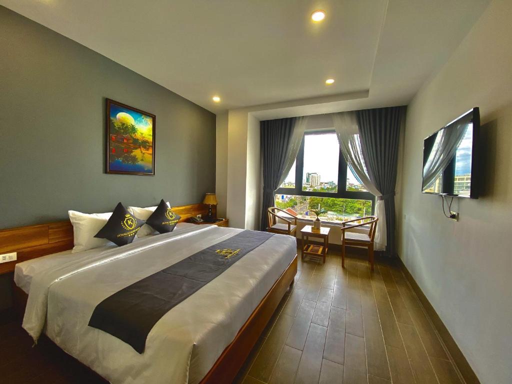 绥和市Royal Khanh Hotel的一间卧室配有一张大床和一张桌子