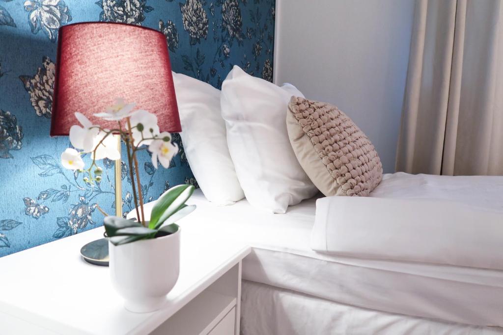斯德哥尔摩Hotel City Living的床上有枕头,花瓶上有鲜花