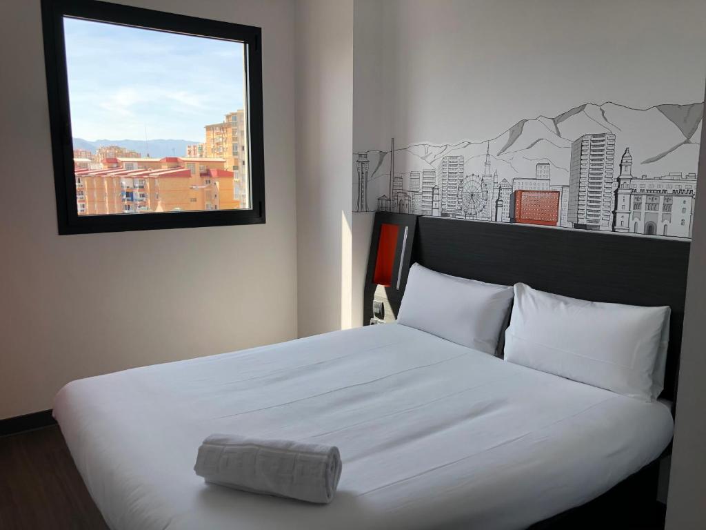 马拉加easyHotel Malaga City Centre的卧室配有一张大白色床和窗户