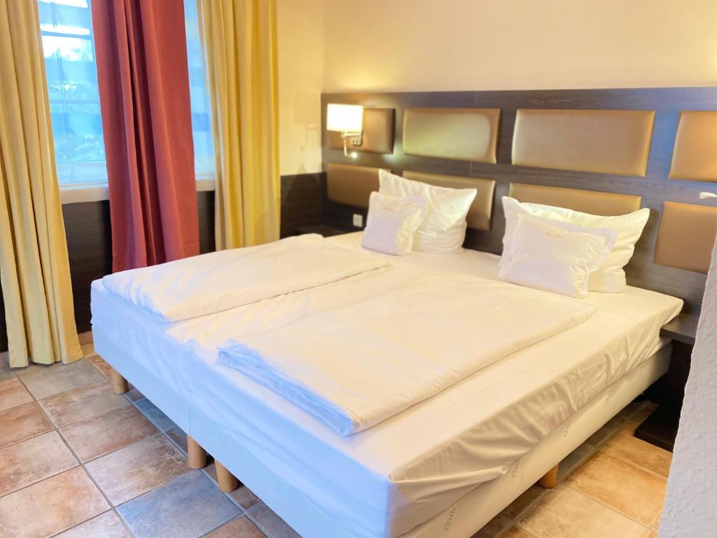 普尔海姆Kontaktlos Hotel Vintage的一间卧室配有带白色床单和枕头的床。