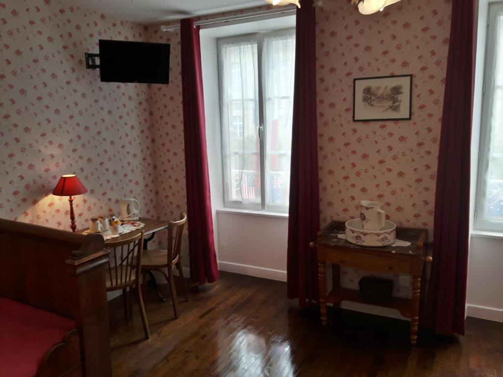 圣梅尔埃格利斯Chambres d'Hôtes et Table d'Hôtes- Valentine 44的一间带桌子和2个窗户的用餐室