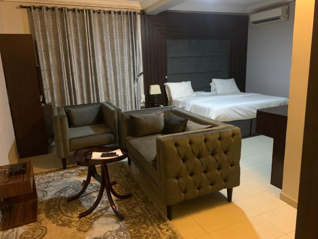 阿布贾SS Suites的酒店客房设有一张沙发和一张床