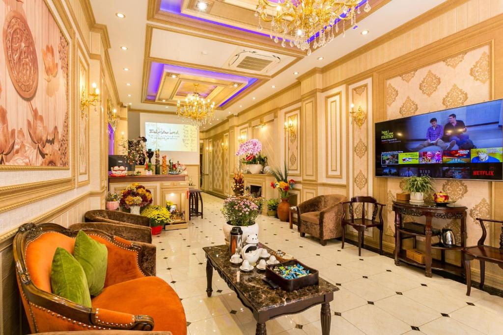 胡志明市Indochine Ben Thanh Hotel & Apartments的大堂配有沙发、椅子和电视。