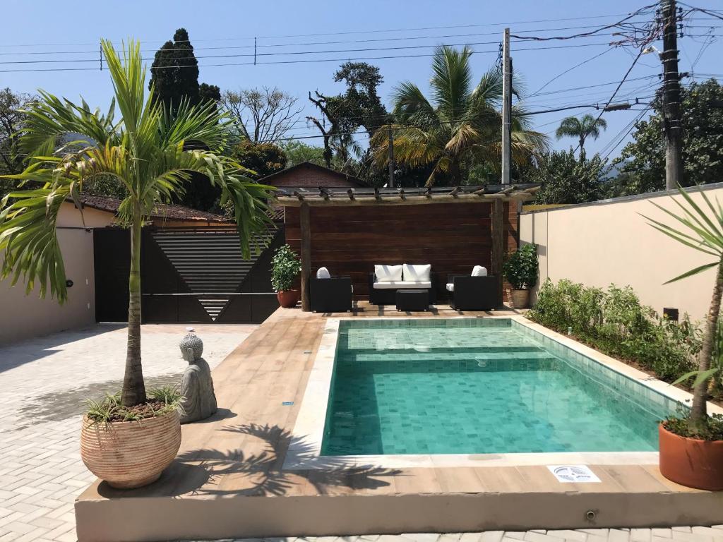 博西坎加Flats de Sumatra的棕榈树房子后院的游泳池
