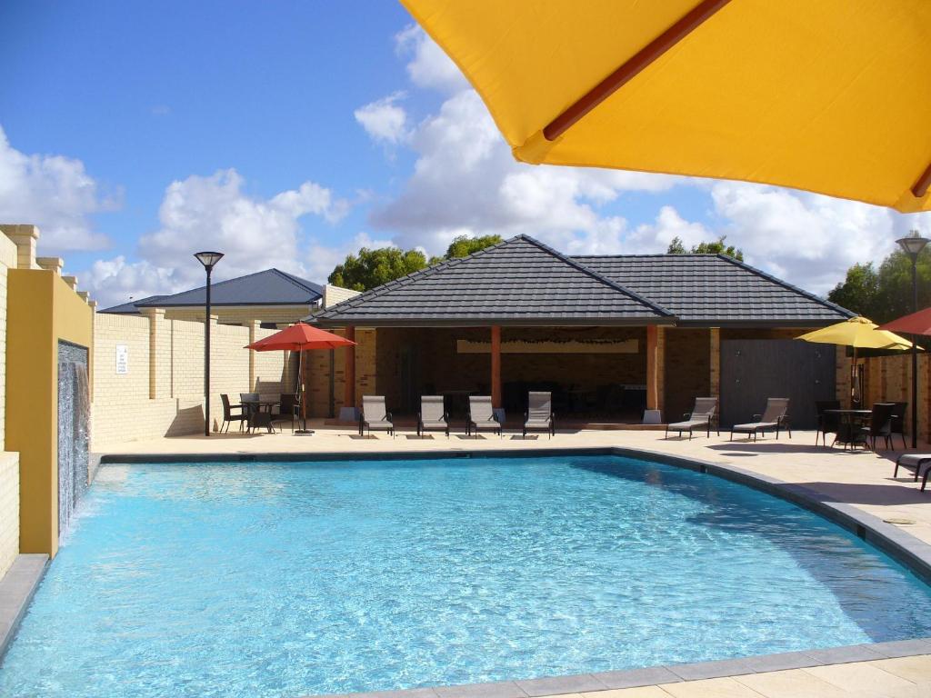 Port Denison丹尼森港海滩度假公寓的一个带椅子和遮阳伞的大型游泳池