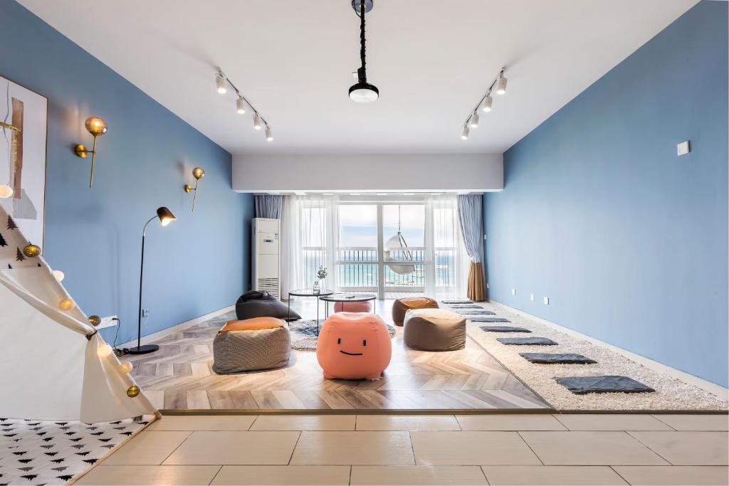 三亚三亚阳光海景公寓的客厅拥有蓝色的墙壁,地板上设有枕头。