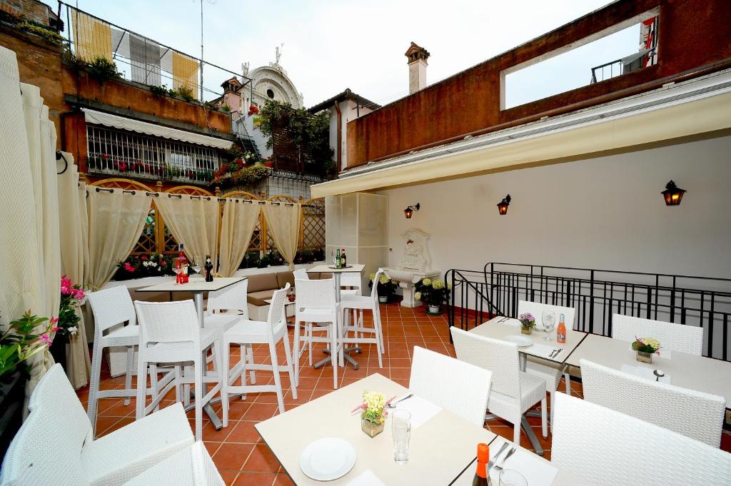 威尼斯丰塔纳酒店的一间设有白色桌子和白色椅子的餐厅