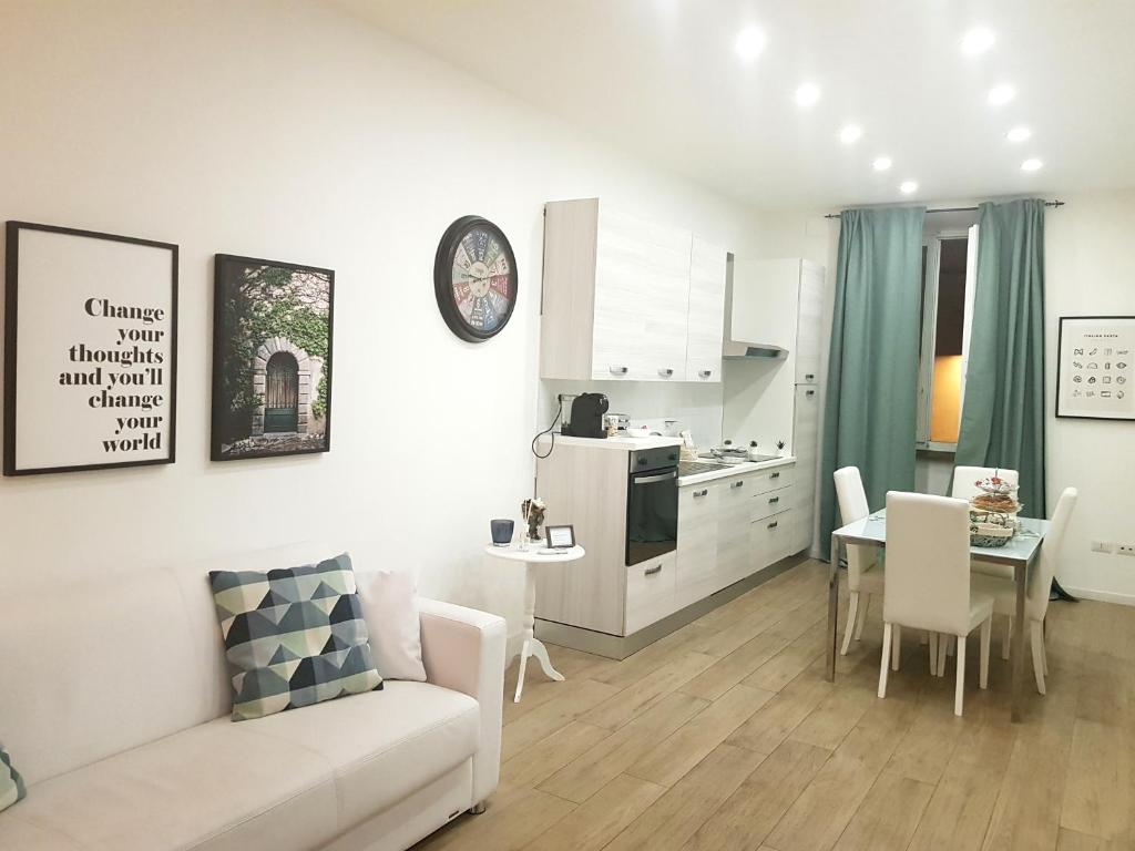 维泰博APARTMENT VITERBO CENTRO CORSO的客厅以及带沙发和桌子的厨房。