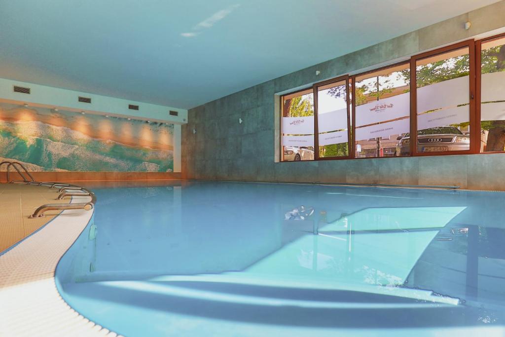加茨比亚格拉Ośrodek wypoczynkowy Balt-Tur Feel Well Resort的客房内的大型游泳池,有蓝色的水