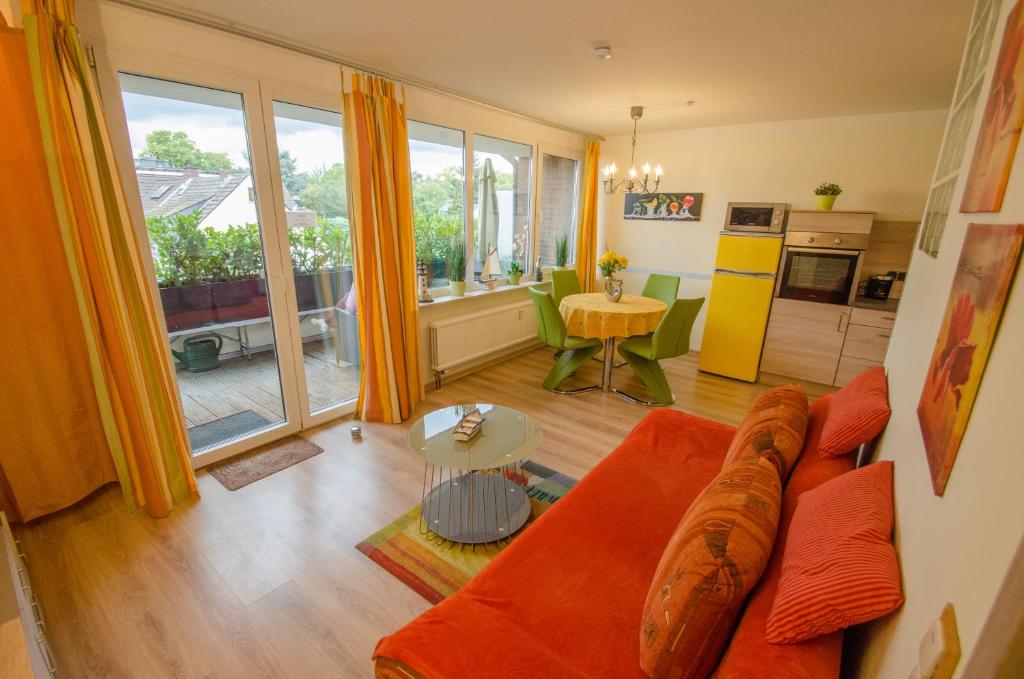科隆Ferienwohnung Cologne的一间带橙色沙发的客厅和一间厨房