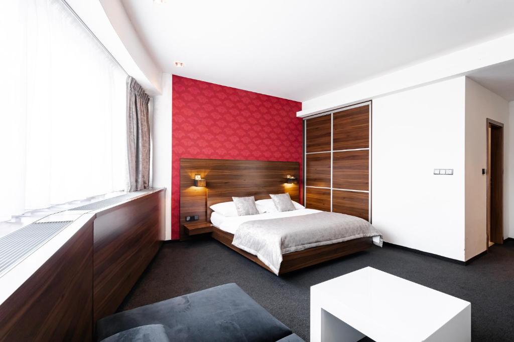 布拉迪斯拉发永丰栈俱乐部加尼酒店的一间卧室设有一张床和红色的墙壁