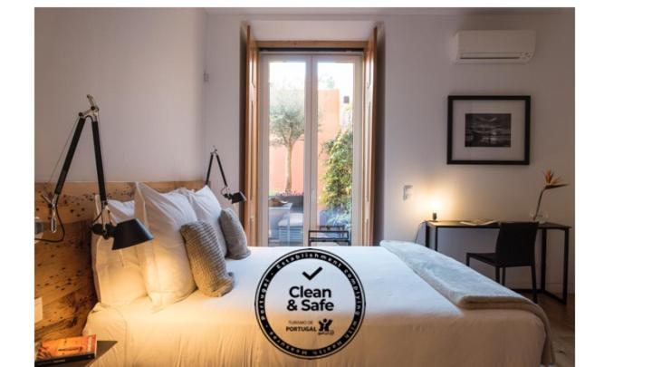 里斯本芙洛拉希亚多公寓的一间卧室,配有一张带标志的床