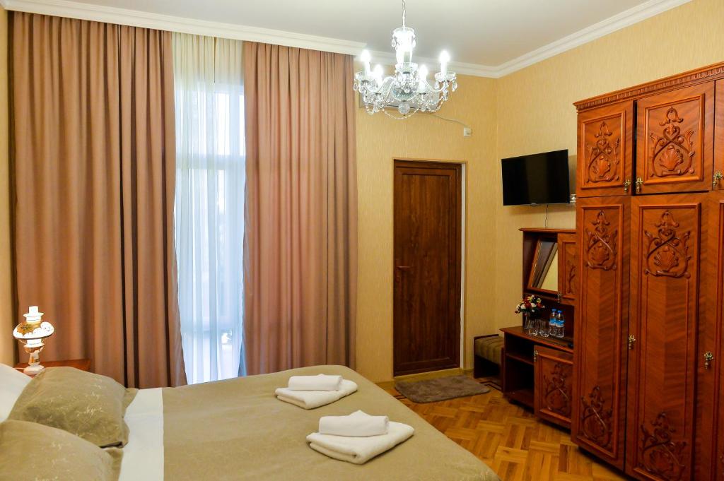 库塔伊西Gold Guest House的一间卧室配有一张大床和一个吊灯。