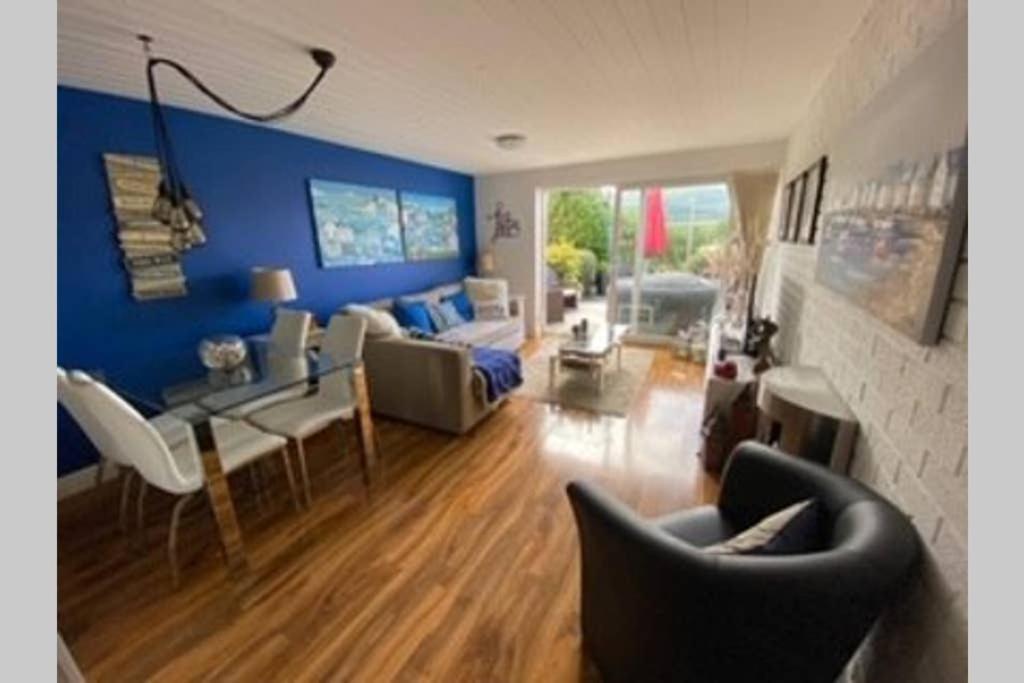 塔桑墨The Little Boat House的客厅拥有蓝色的墙壁和桌椅