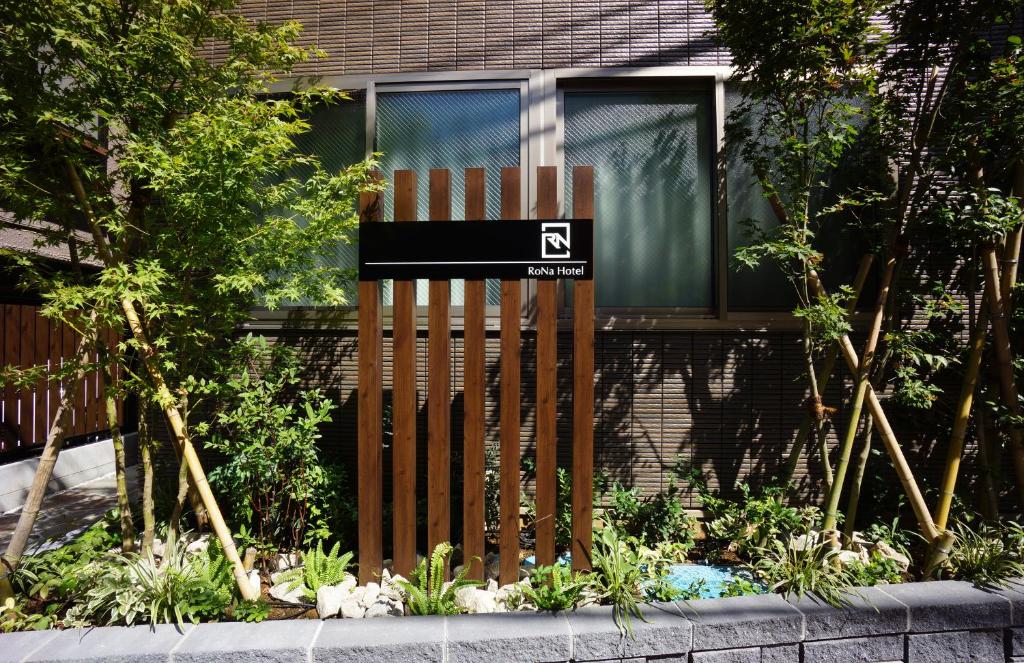 东京RoNa Hotel的房屋前有标志的木栅栏