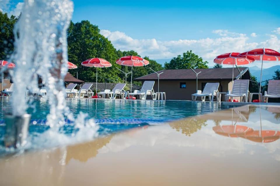 阿普里尔齐Хотелски комплекс САНЯ的游泳池设有喷泉,配有椅子和遮阳伞