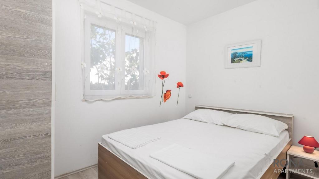 伊穆尼Rona Apartments Zlatko的白色的卧室设有床和窗户