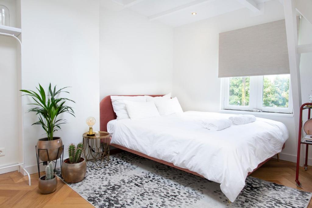 阿姆斯特丹Trendy 2 bedroom accommodation on perfect location的卧室配有白色的床和窗户。