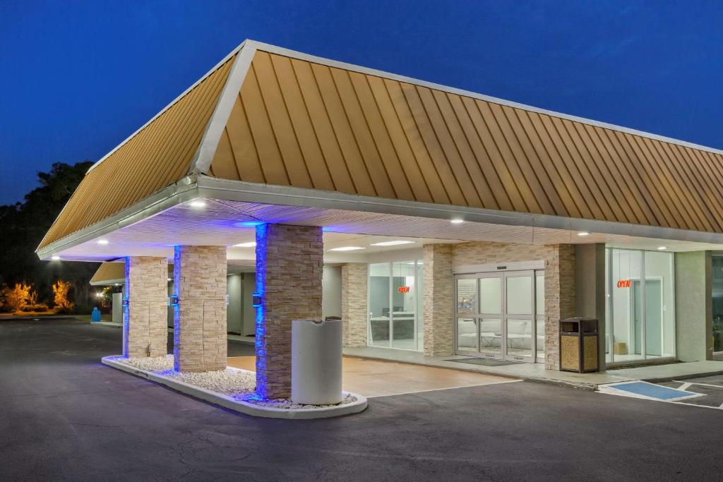 帕瓦雷斯岛Quality Inn & Suites的停车场内有紫色灯的屋顶的建筑