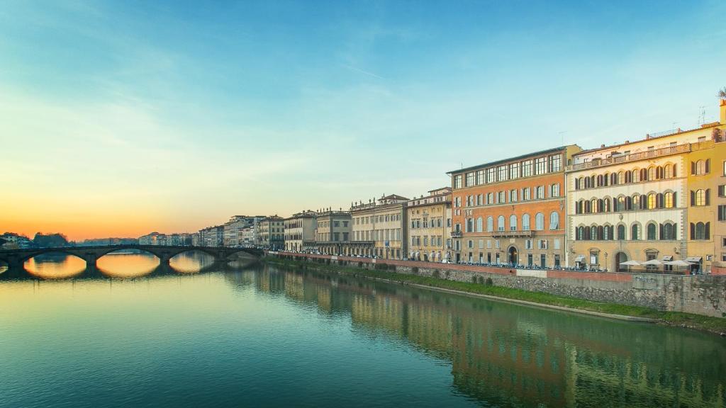 佛罗伦萨Hotel Bretagna Heritage - Alfieri Collezione的享有河流美景,设有建筑和桥梁