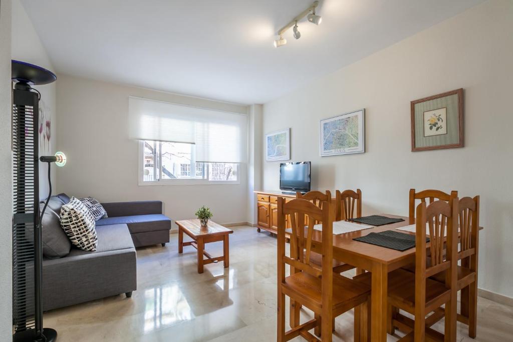 塞维利亚Apartamento cerca del Alcázar con garaje privado的客厅配有桌子和沙发
