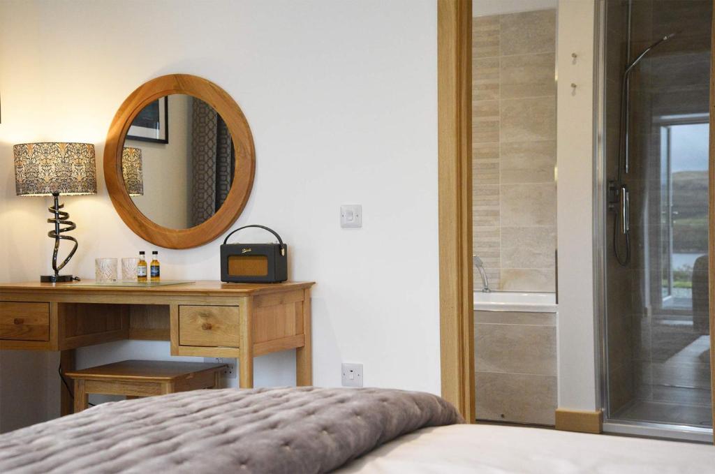 Port na LongWoodland Lodge的一间带镜子、一张床和一张书桌的卧室