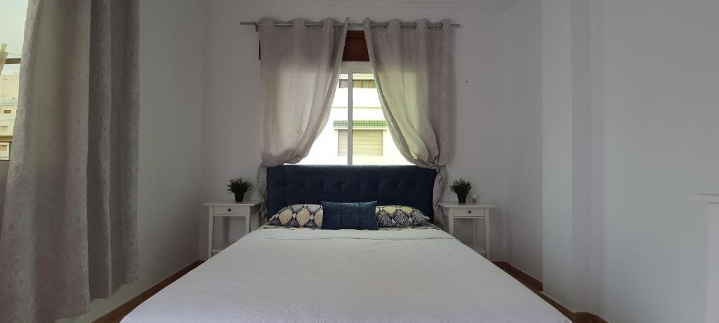 米迪克Jolie appartement vue mer的一间卧室设有一张大床和窗户