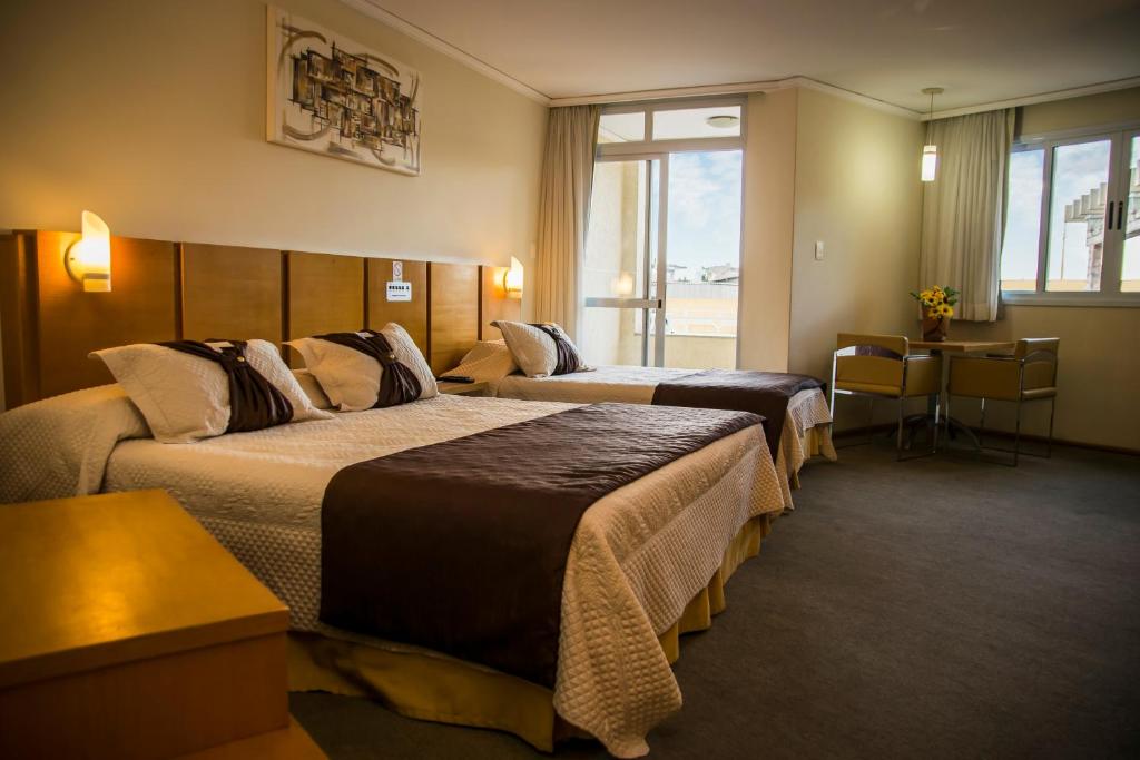 蓬塔格罗萨巴布广场酒店的酒店客房,设有两张床和一张沙发