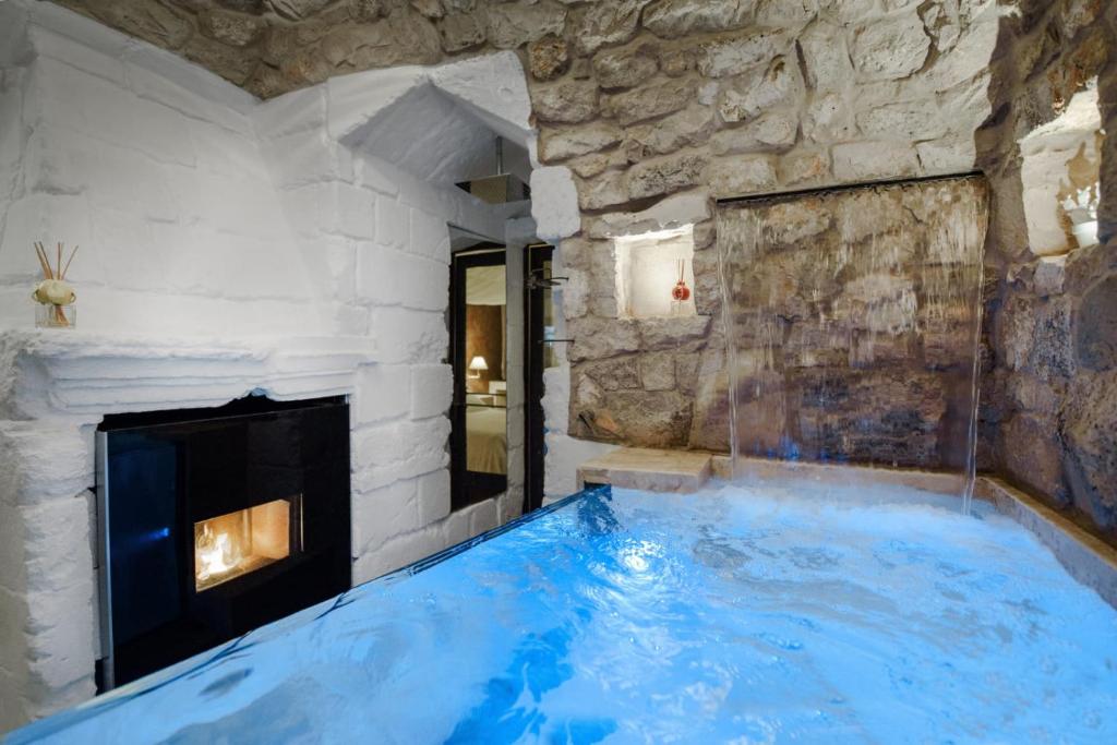加拉蒂纳Egò Salento的带壁炉的客房内的大型蓝色浴缸
