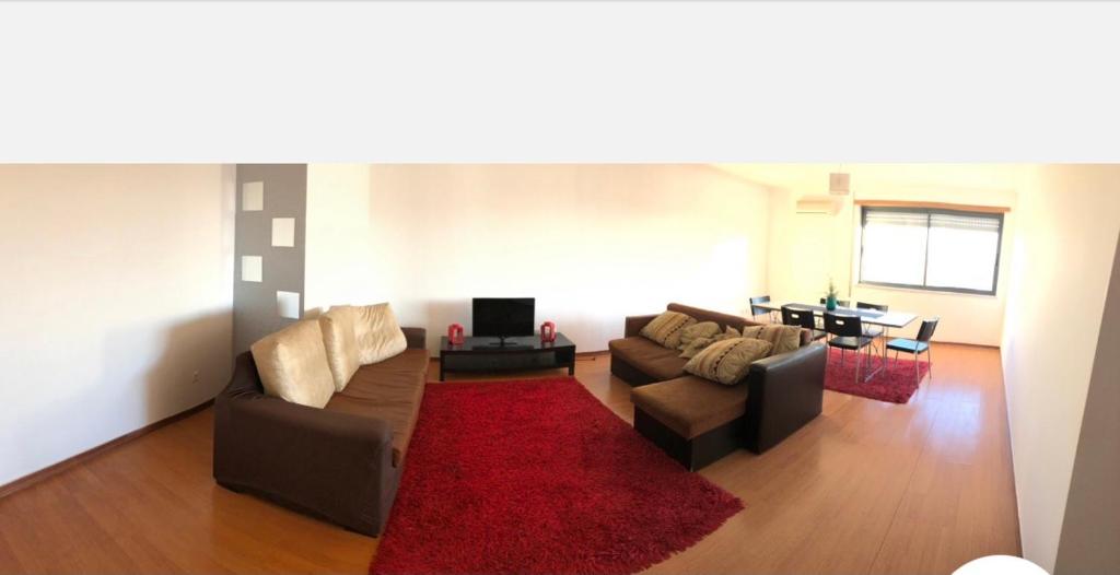 蒙蒂茹Wonderful apartament Lisbon的客厅配有两张沙发和红色地毯