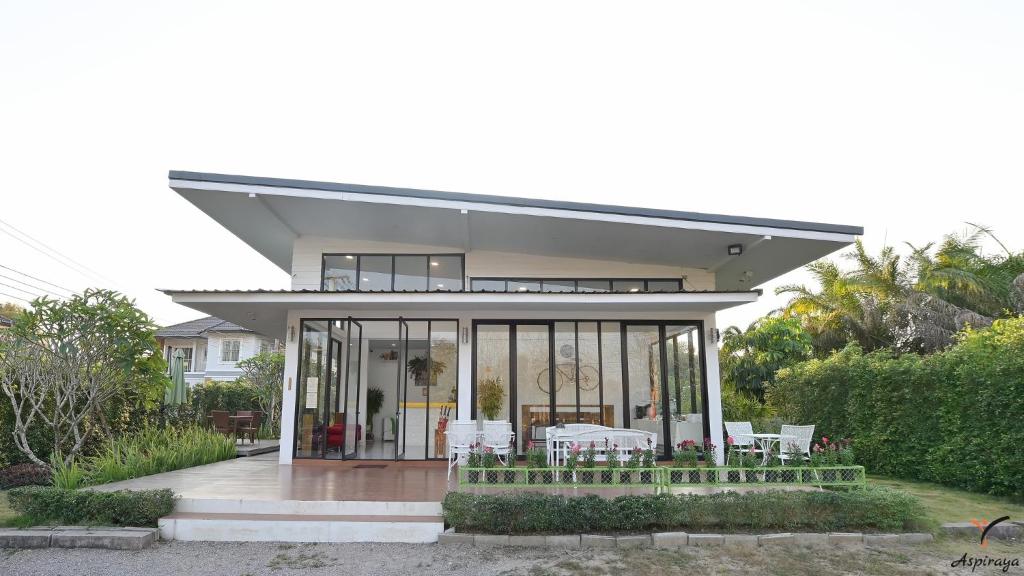 清莱Aspiraya Resort的一座带玻璃门和桌椅的房子
