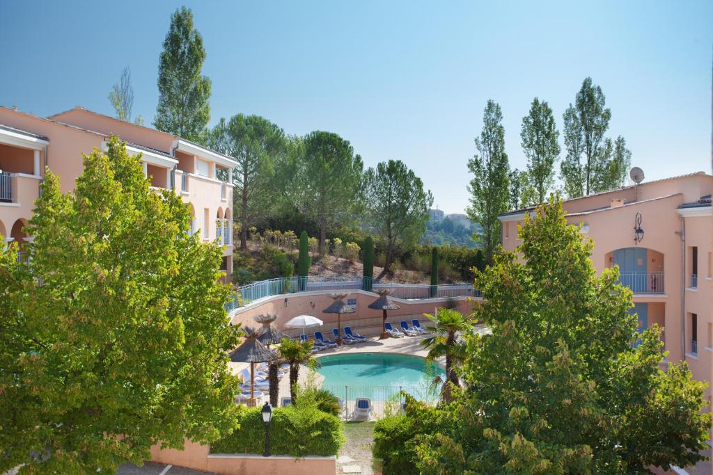 格雷乌莱班奥达里斯拉里科尔内利乌斯德奥特普罗旺斯公寓式酒店的享有带游泳池和树木的度假村景色
