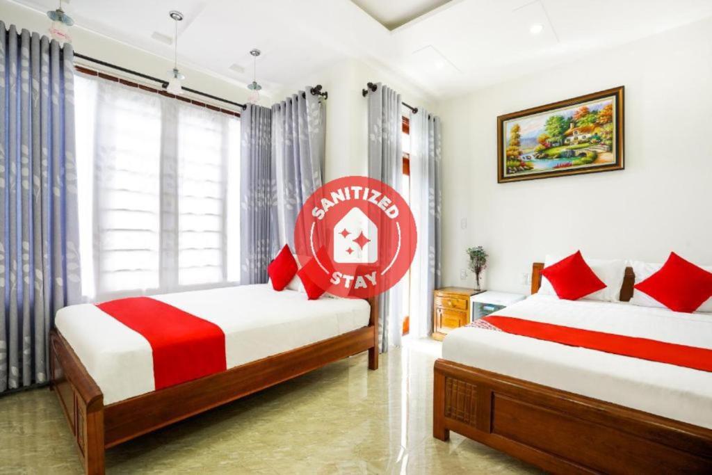 会安Legend Connect Homestay的卧室配有两张床,墙上挂有红色标志