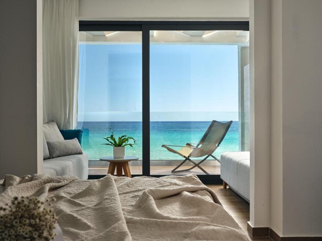 查加基恩Cavo Orient Beach Hotel & Suites的一间卧室配有一张床,享有海景