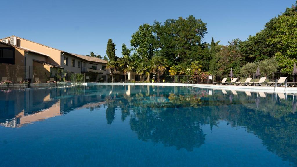德龙河畔洛里奥勒Logis Hotel Restaurant SPA Les Oliviers的度假村内的一个蓝色海水游泳池