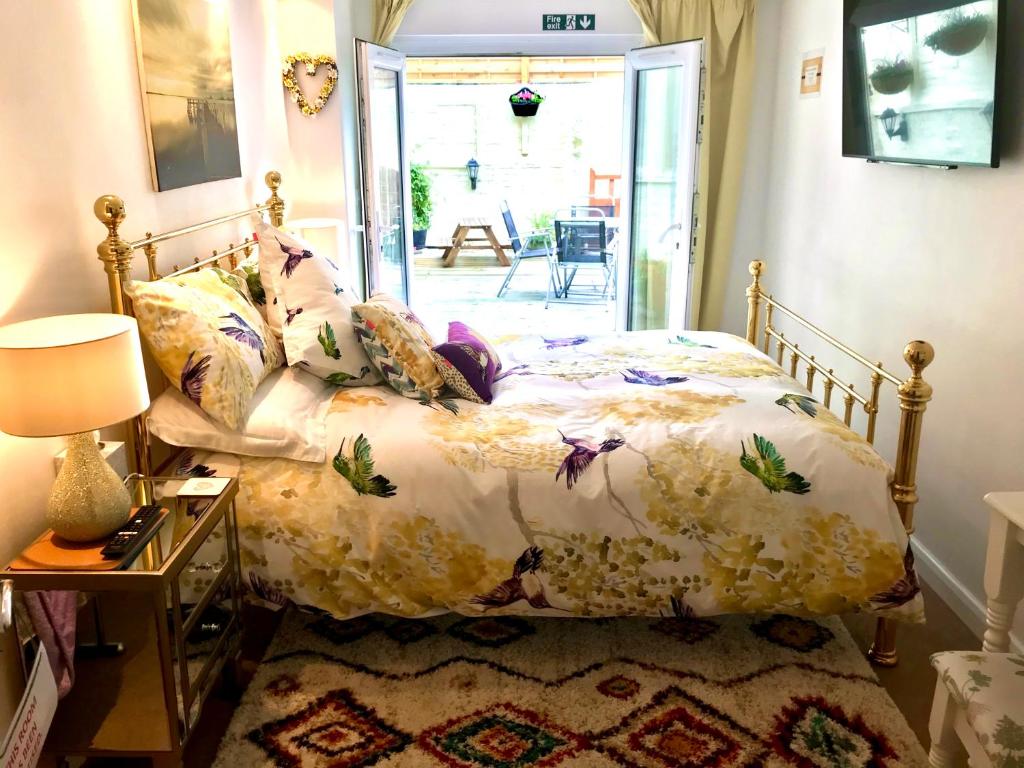 克罗默The Old Bakery的一间卧室配有一张带花卉棉被的床