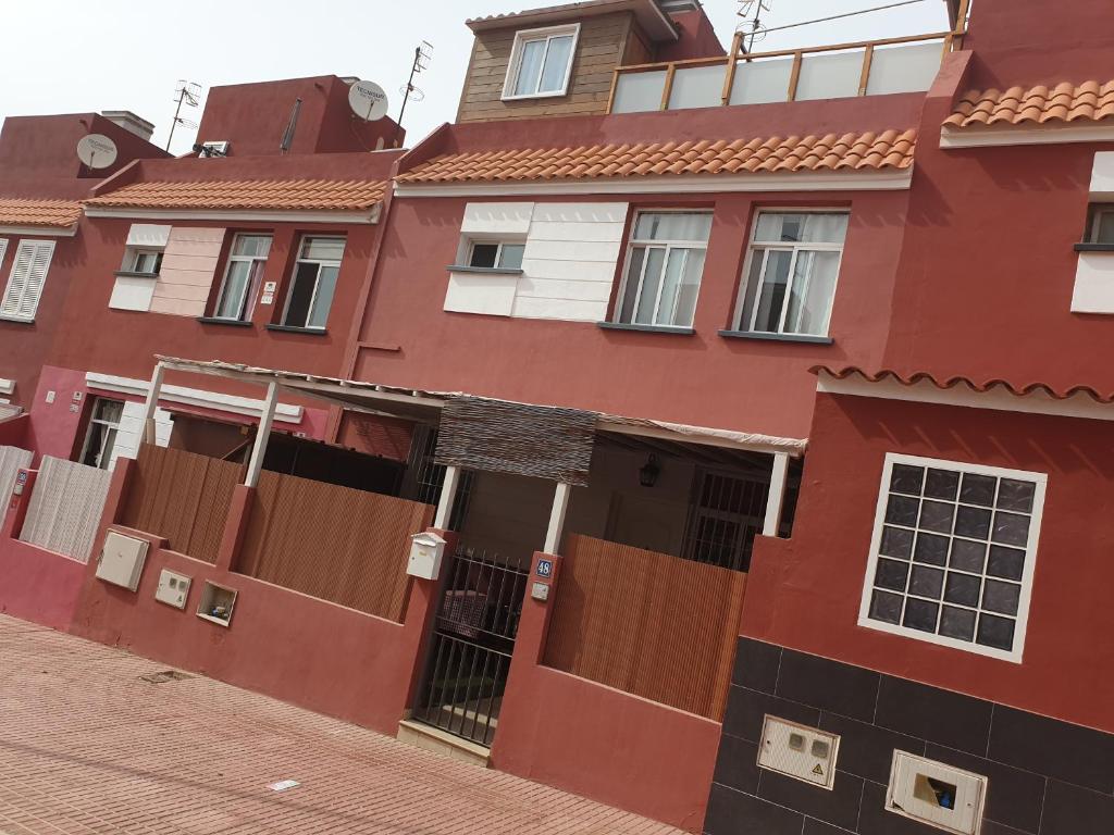 圣伊西德罗Kiki vivienda Bed & breakfast的街上有红色的建筑,有棕色的门