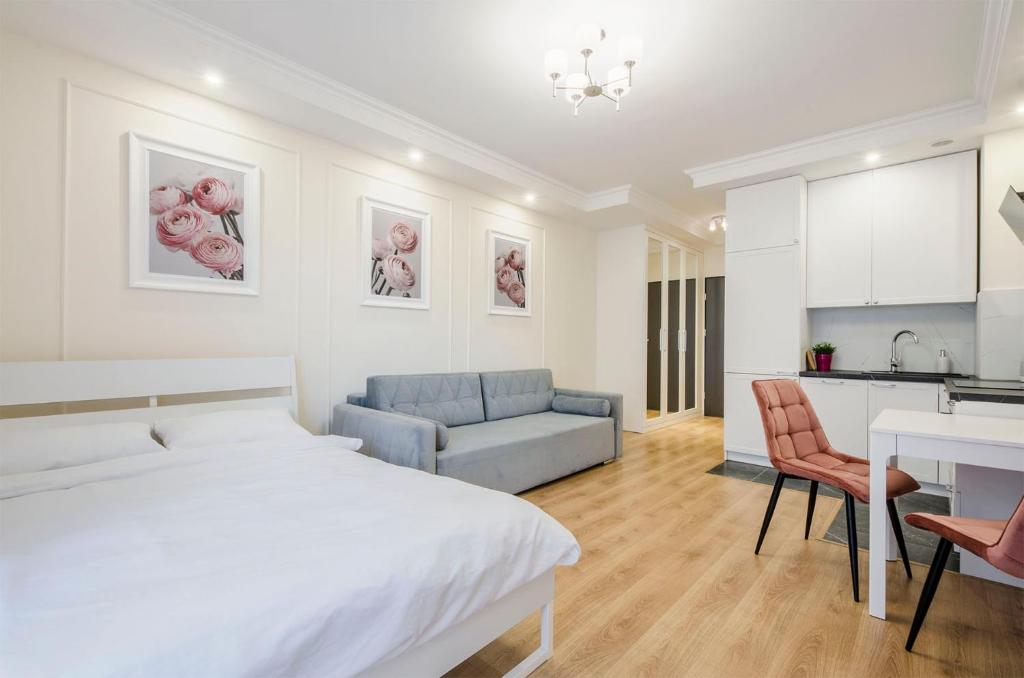 罗兹ApartHouse Deluxe的一间白色卧室,配有床和厨房