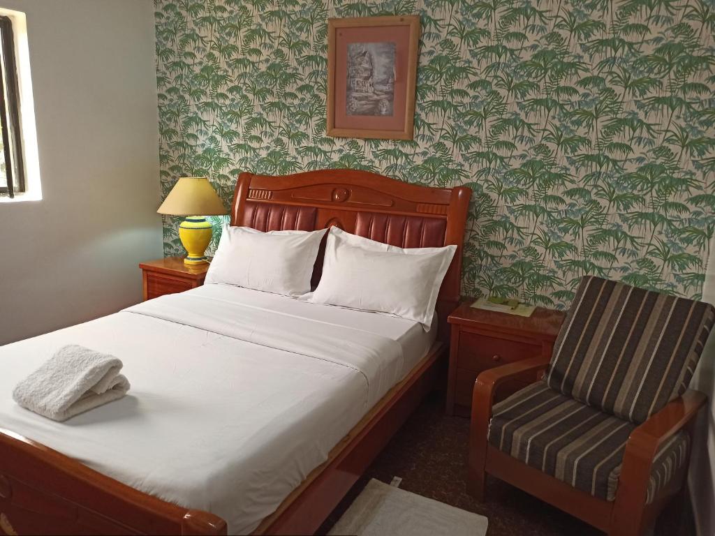 科托努Hotel Saint-Jean的一间卧室配有一张床和一把椅子