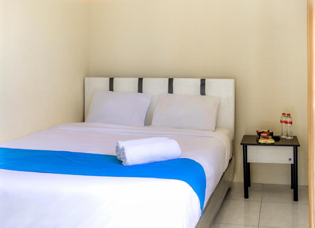 泗水City Residence Kutai 32的卧室配有一张白色床和边桌