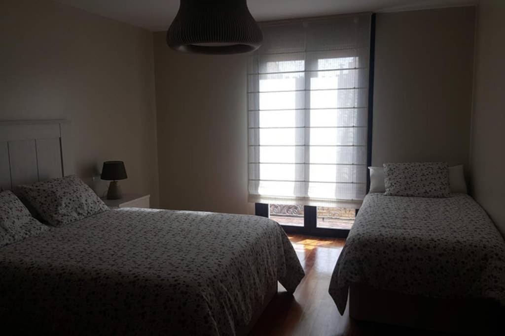 拉瓜迪亚Casa Mercedes. Laguardia (Alava)的一间卧室设有两张床和窗户。