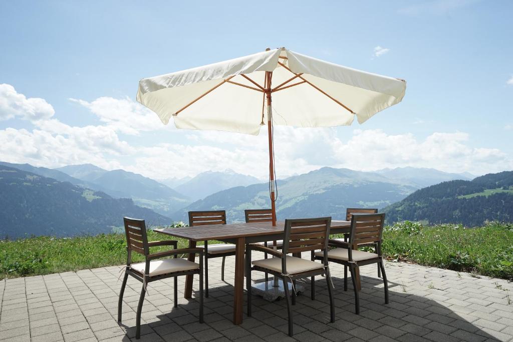 法莱拉Clasgieri - 3-Zimmer-Ferienwohnung für 4 - 6 Personen, 65m2的一张带椅子的木桌和一把伞