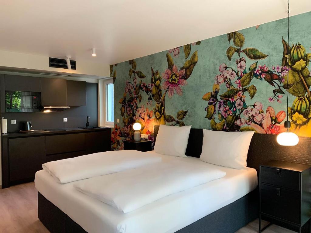 卡尔斯鲁厄ANA Living Karlsruhe by Arthotel ANA的一间卧室设有一张带花卉墙壁的大床