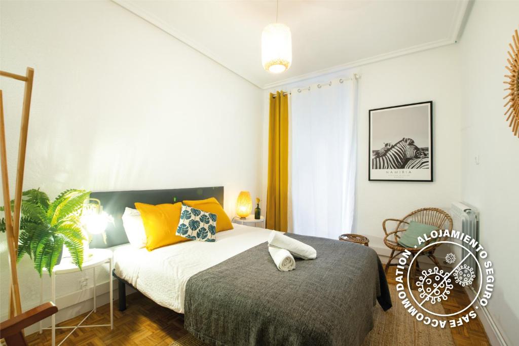 圣塞瓦斯蒂安Espacioso, Moderno y a pie de Playa Zurriola的一间卧室配有一张床和一把椅子