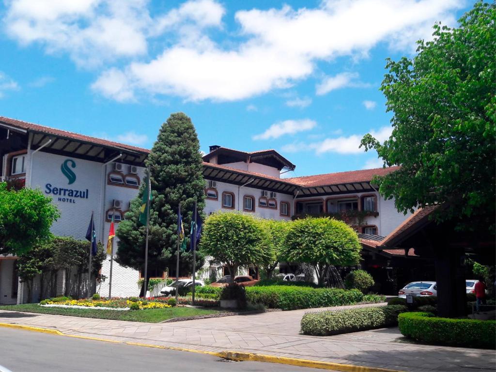 格拉玛多Serrazul Hotel Distributed By Intercity的街道前有树的建筑