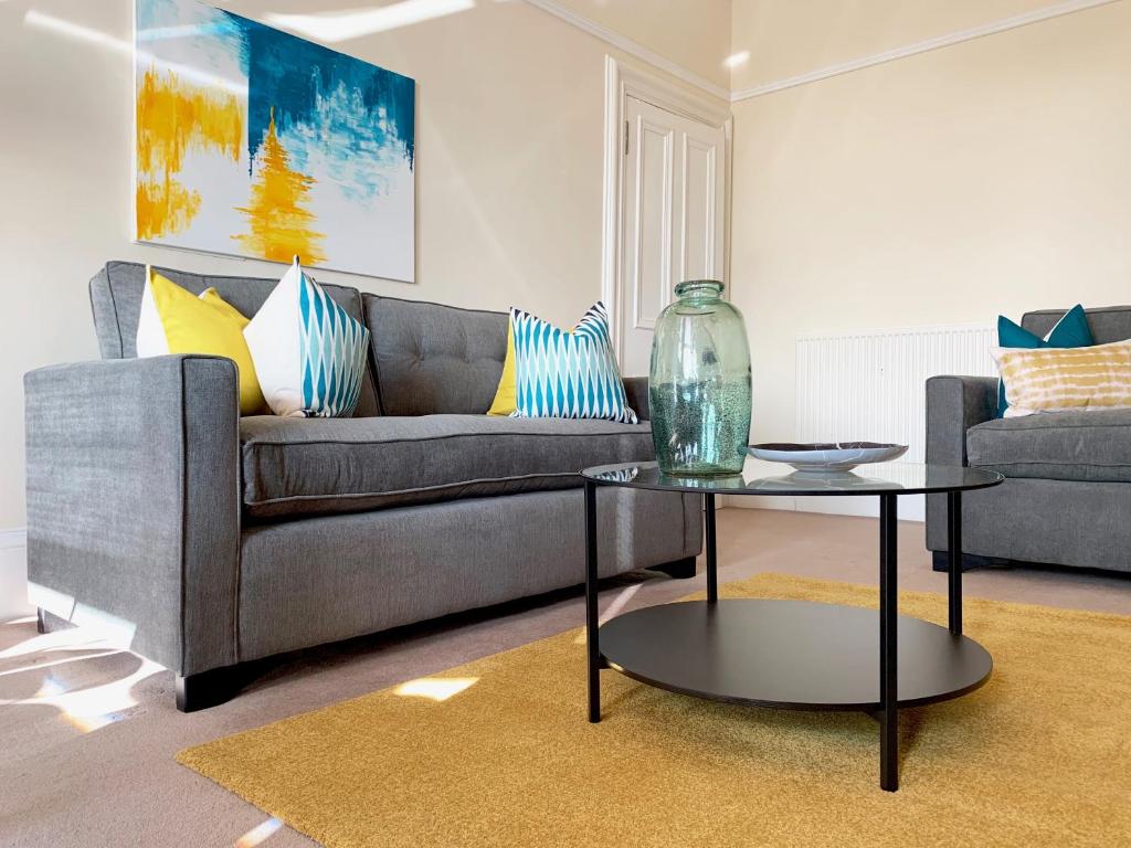 邓迪Tay View Apartment的客厅配有沙发和桌子