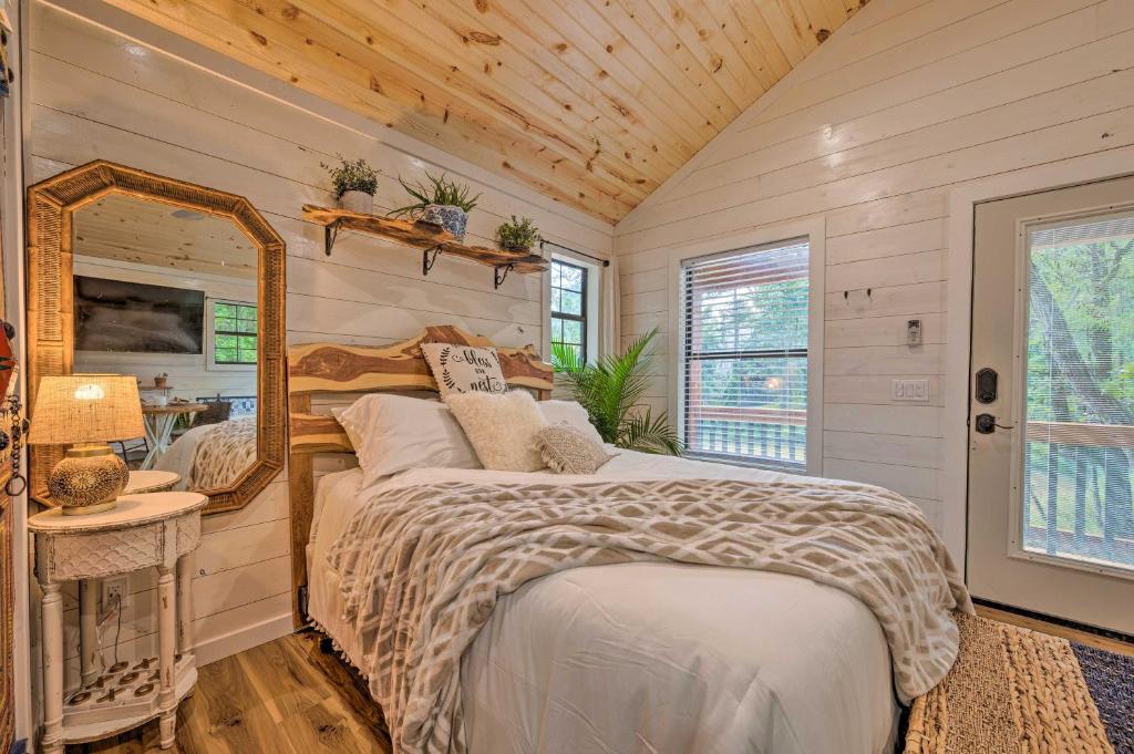 布罗肯鲍Romantic Broken Bow Cabin with Jacuzzi and Fire Pit!的一间卧室配有一张床和镜子