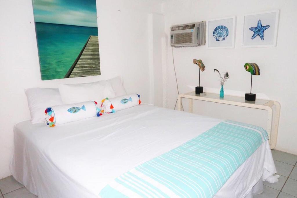 SavanetaApartment Brazil Beach Front Paradise的卧室配有白色的床和2个枕头